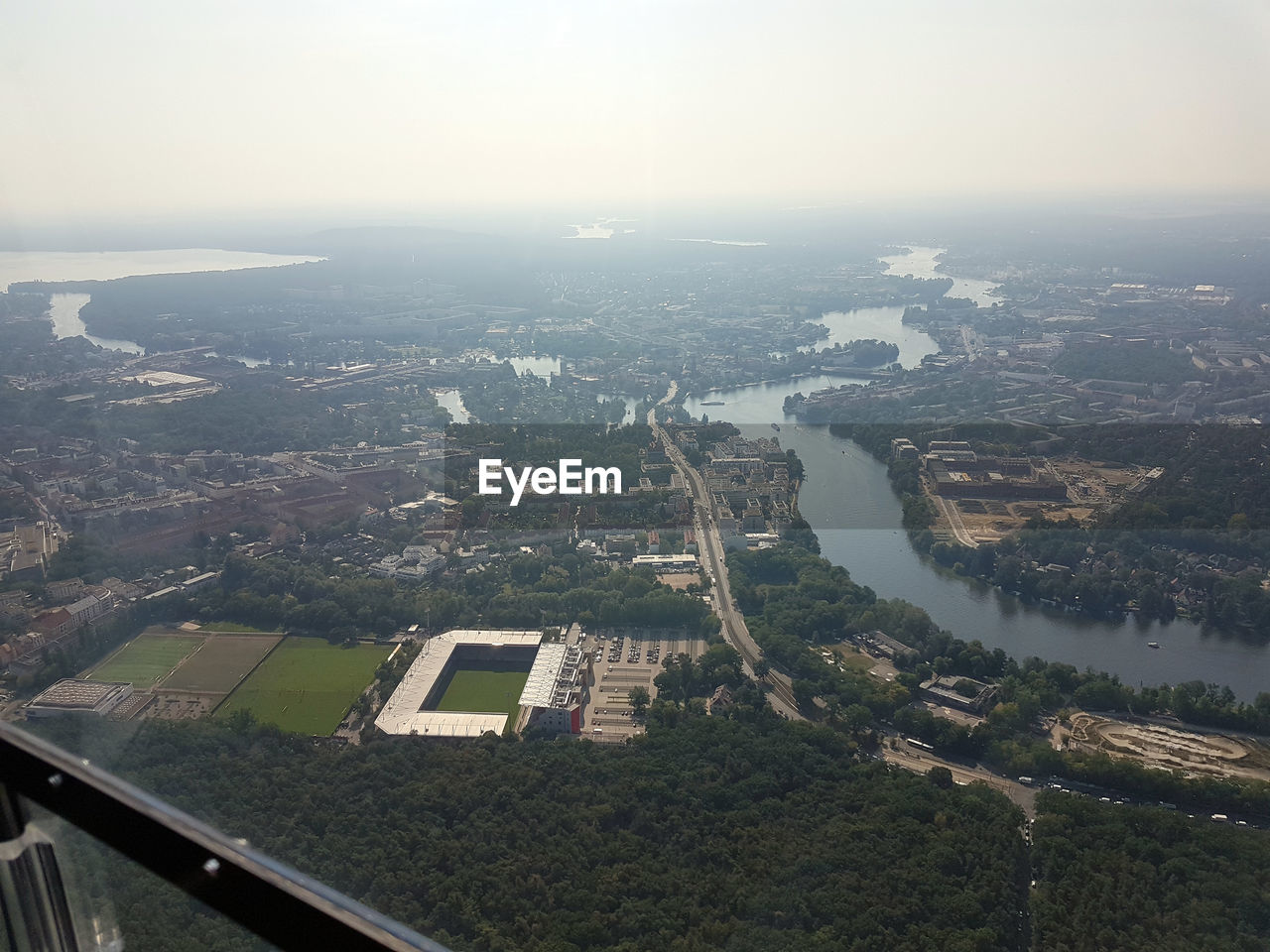 HIGH ANGLE VIEW OF CITY BY RIVER AGAINST SKY