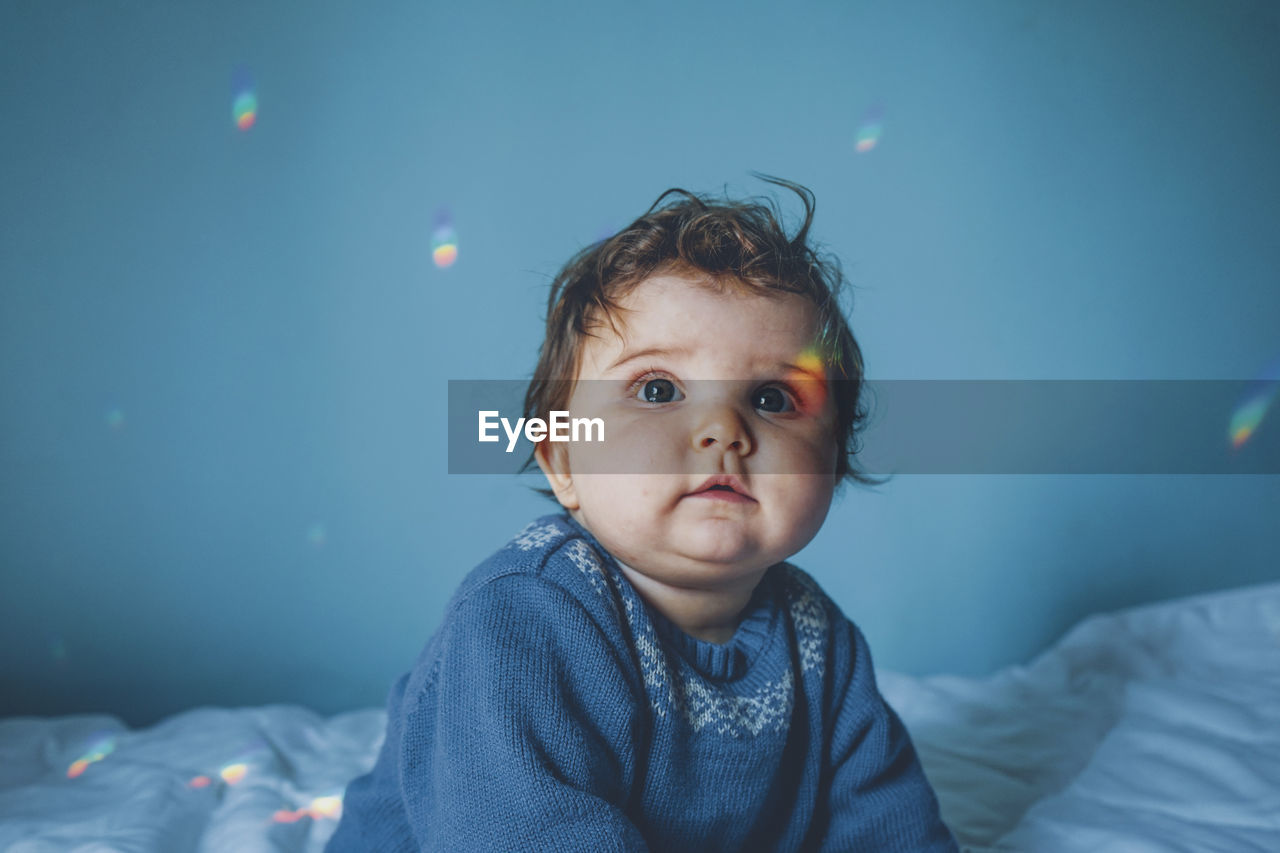 Cute baby girl on bed at home