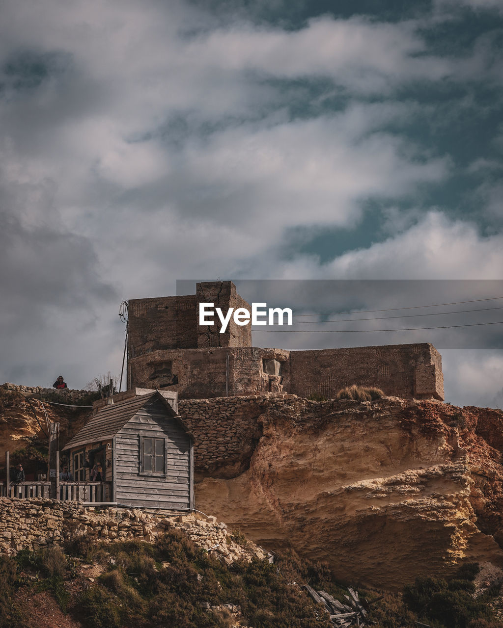 Low angle view of old buildings against cloudy sky