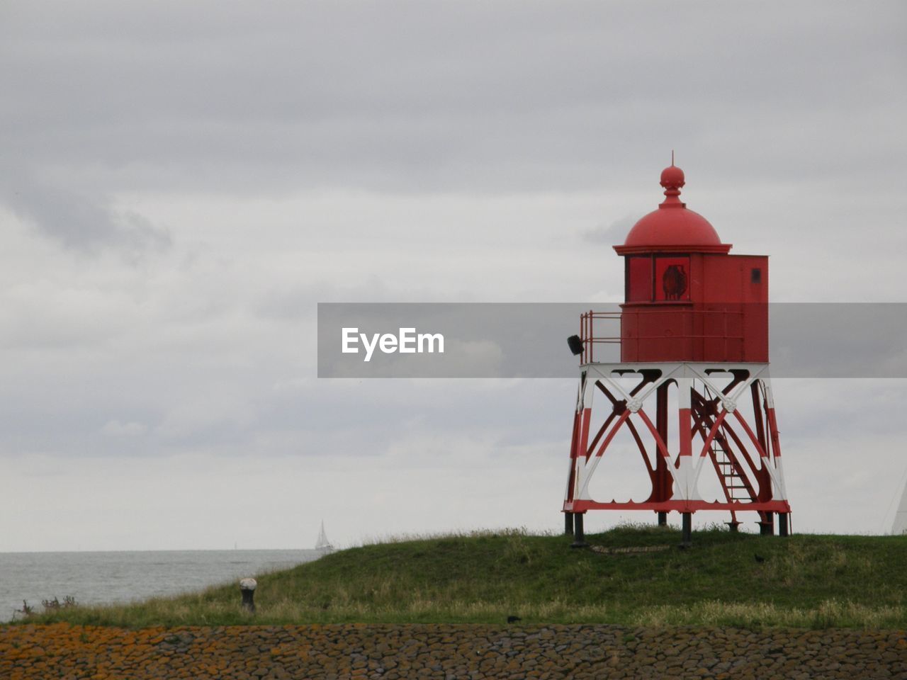 Lighthouse by sea against sky