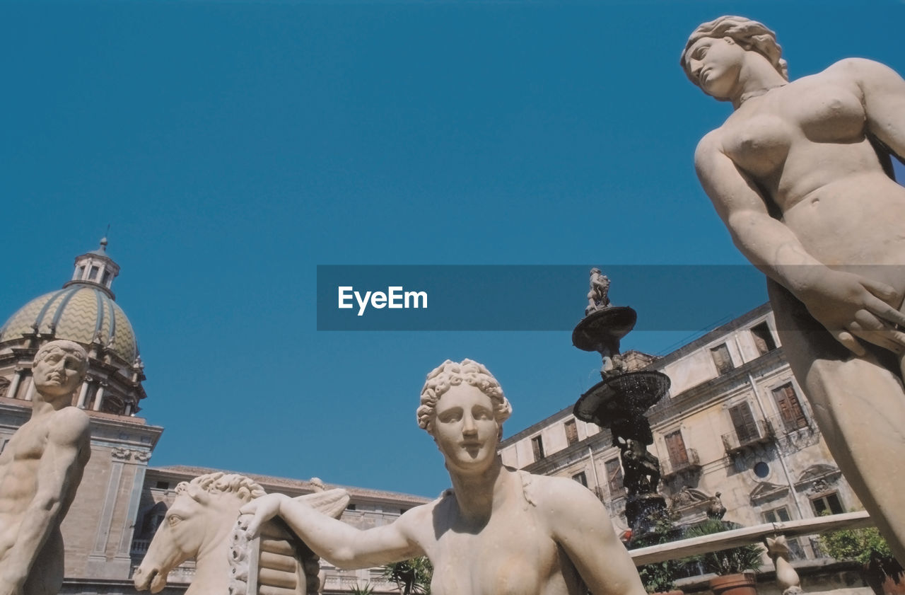 Low angle view of statue against blue sky