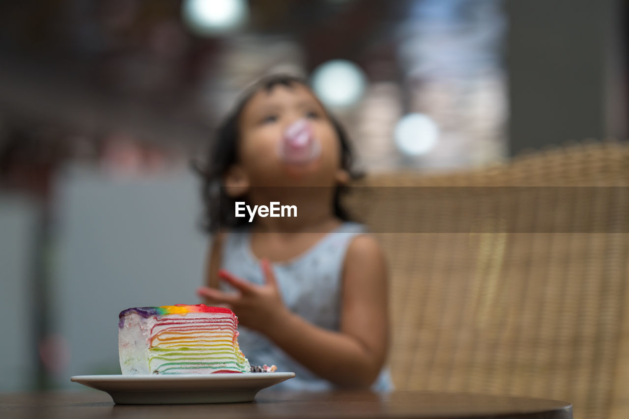 Close-up of cake on table with girl in background