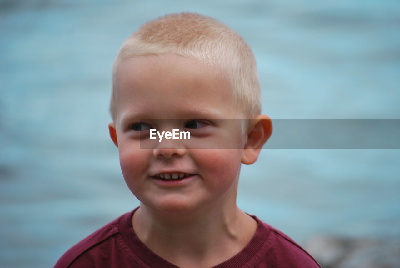 Close-up of smiling boy looking away