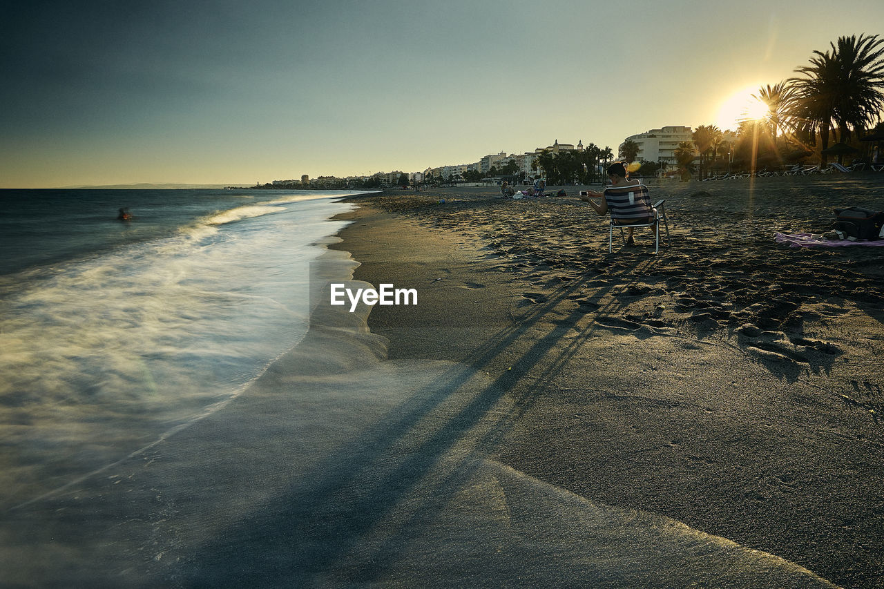 SCENIC VIEW OF BEACH AGAINST SKY DURING SUNSET