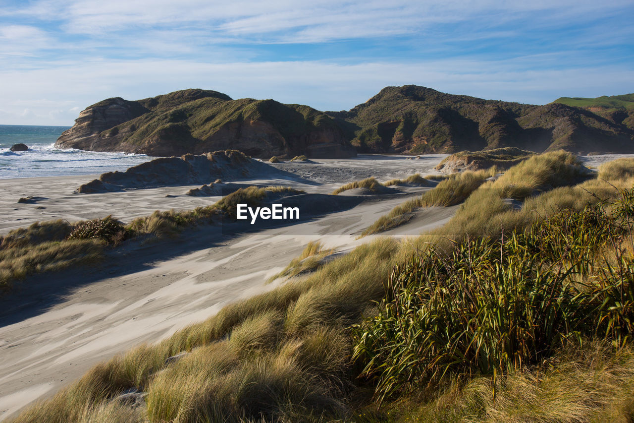 Scenic view of sea and mountains against sky