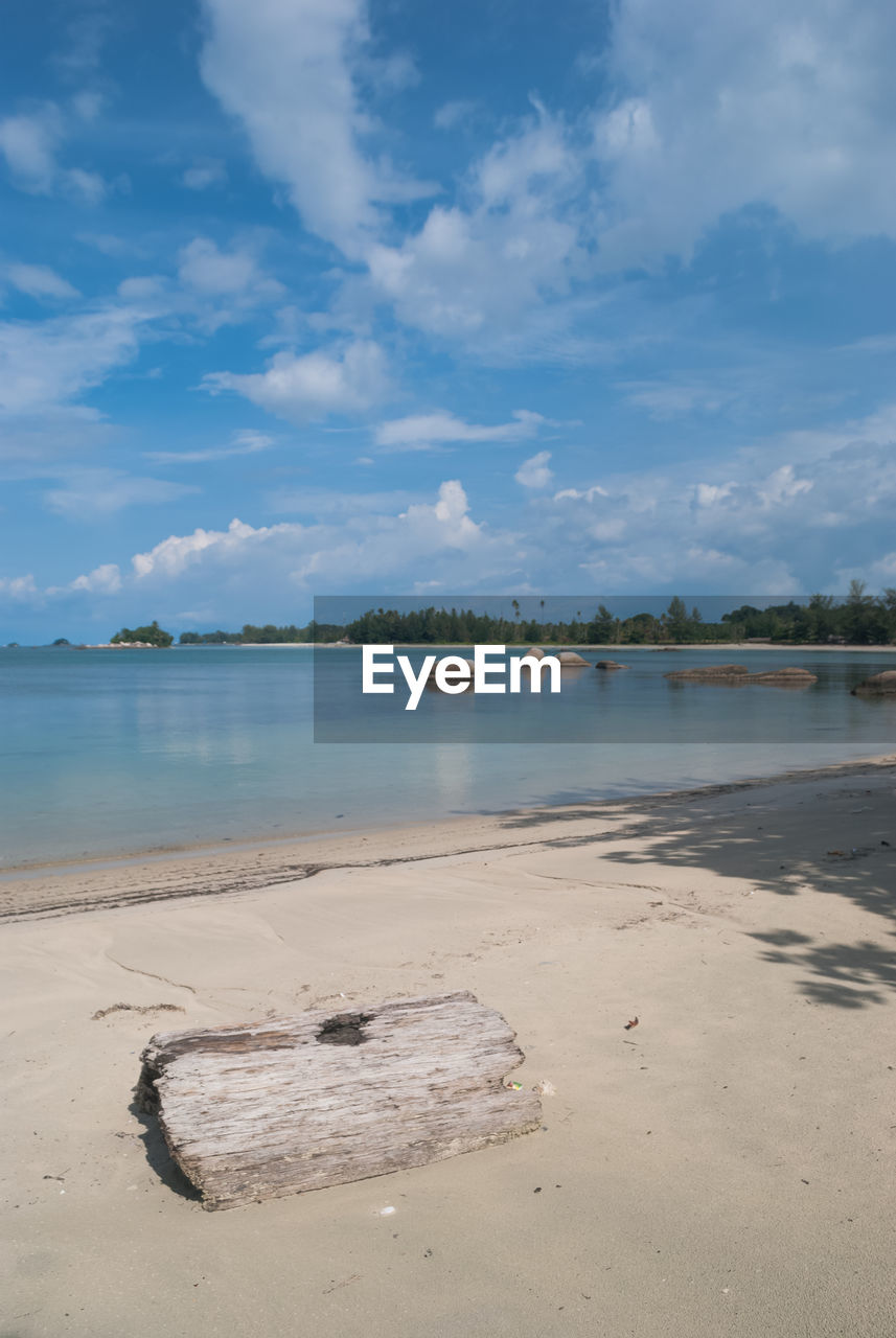 Scenic view of beach against cloudy sky