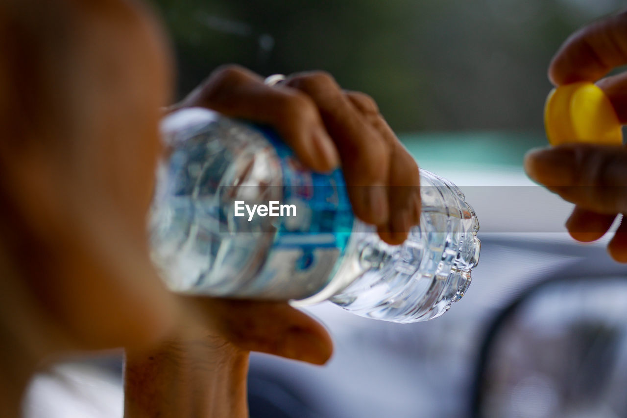 Close-up of person drinking water from bottle