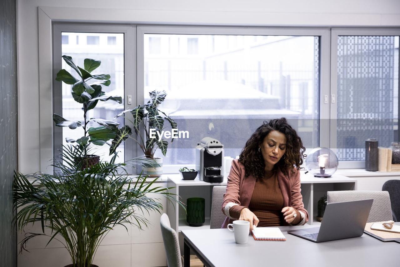 Pregnant female professional working at desk in office