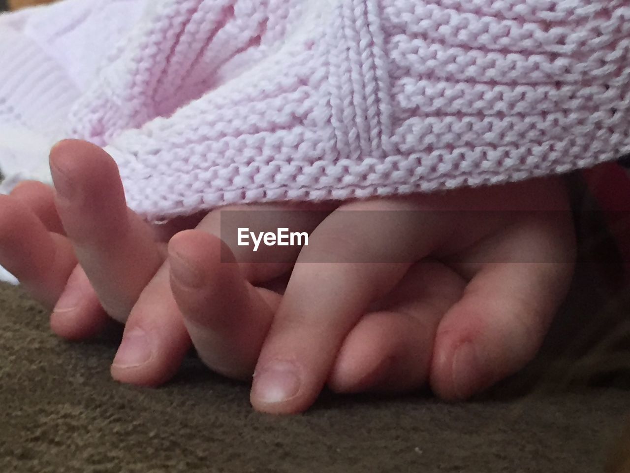 Close-up of girl hands with woolen cloth on rug