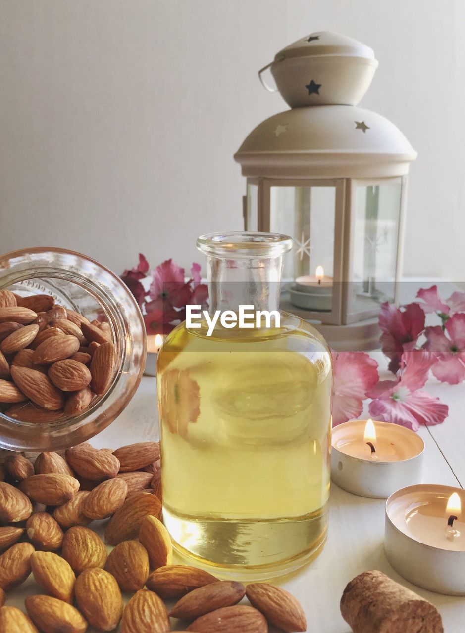 Close-up of almonds and oil in bottle on table