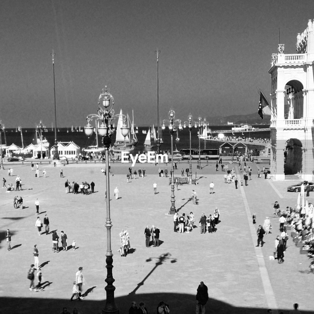 High angle view of people on street by historic building against clear sky