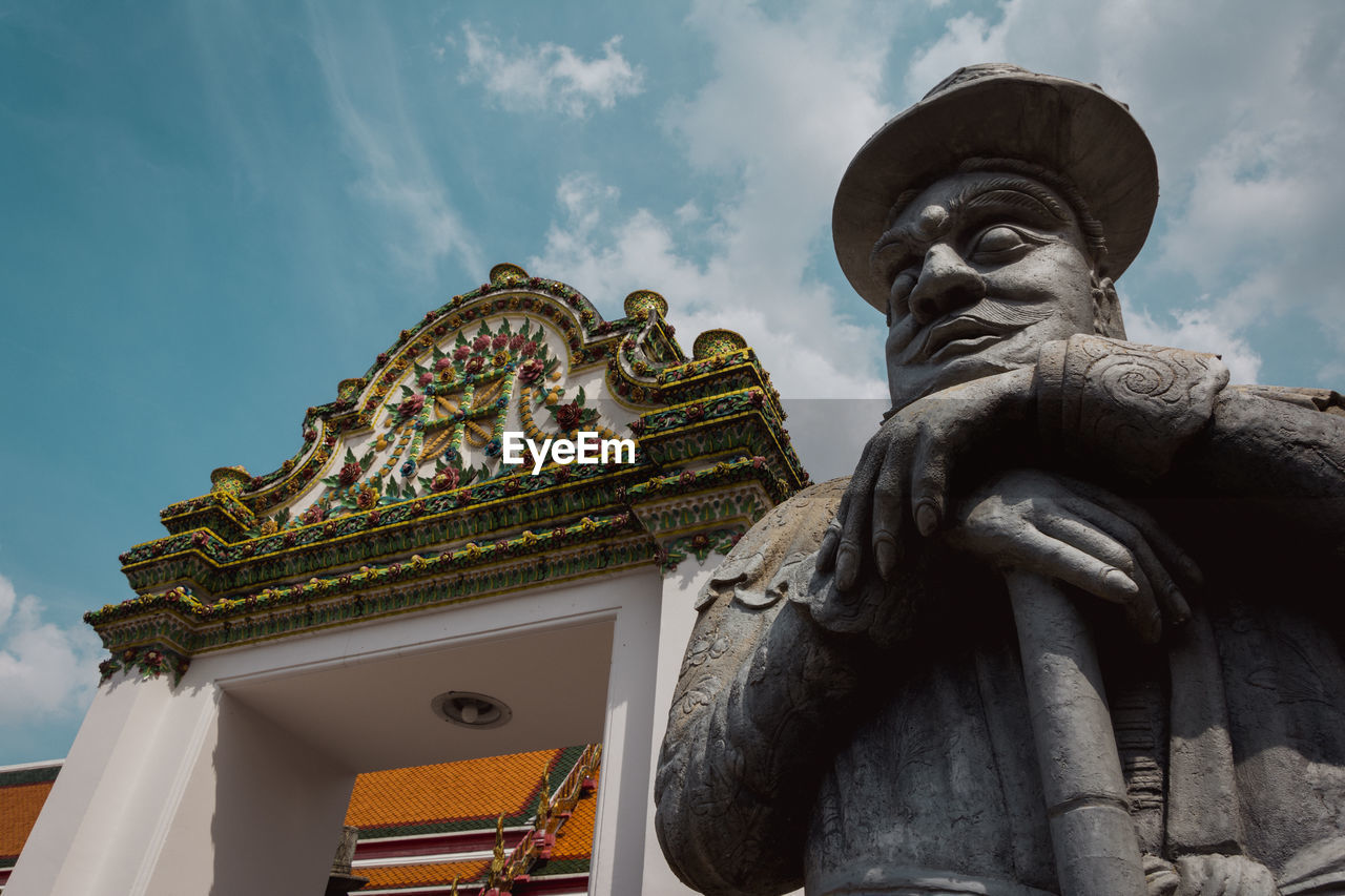 LOW ANGLE VIEW OF STATUE AGAINST TEMPLE