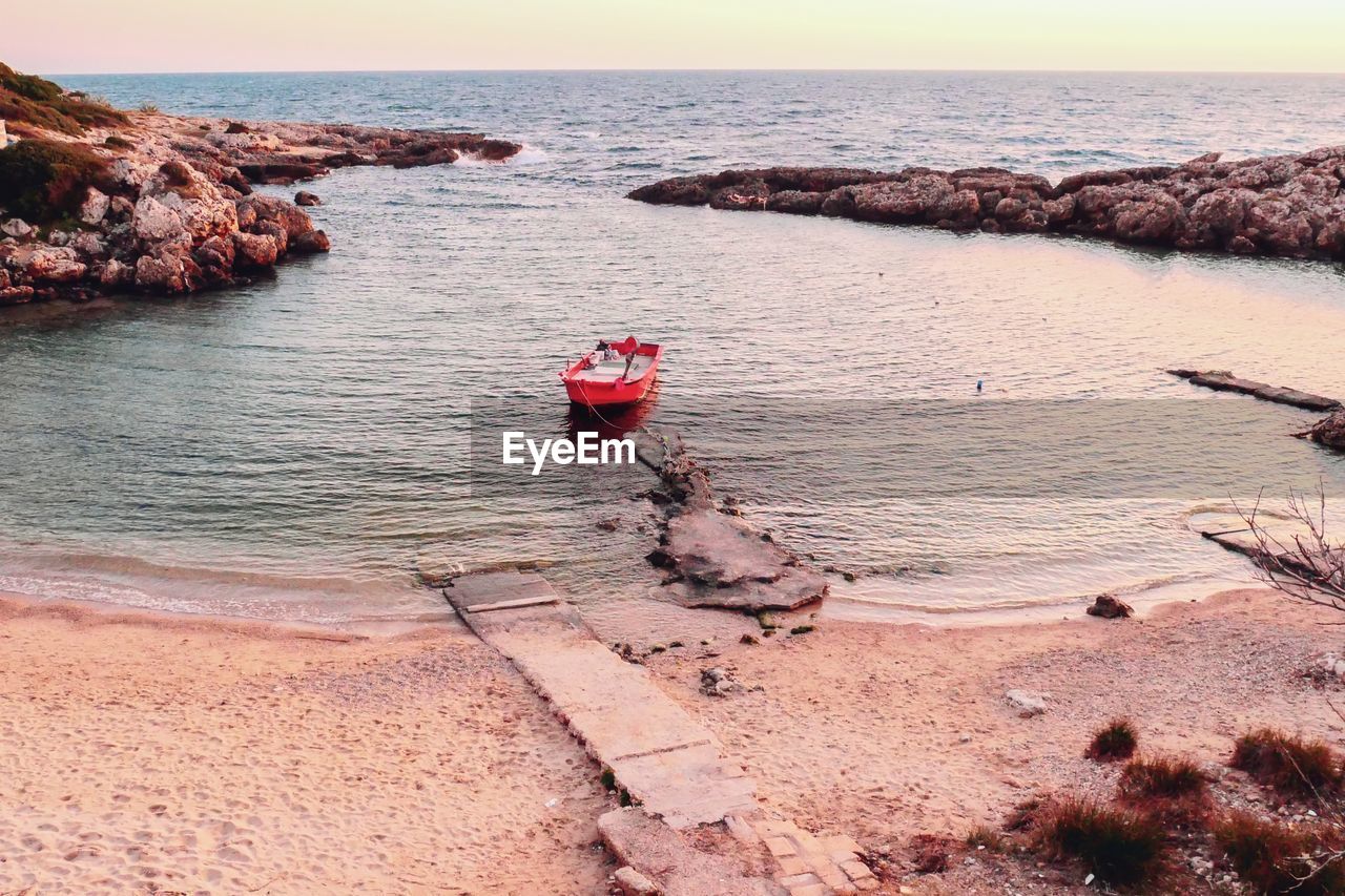 Scenic view of sea and lonely boat against sky