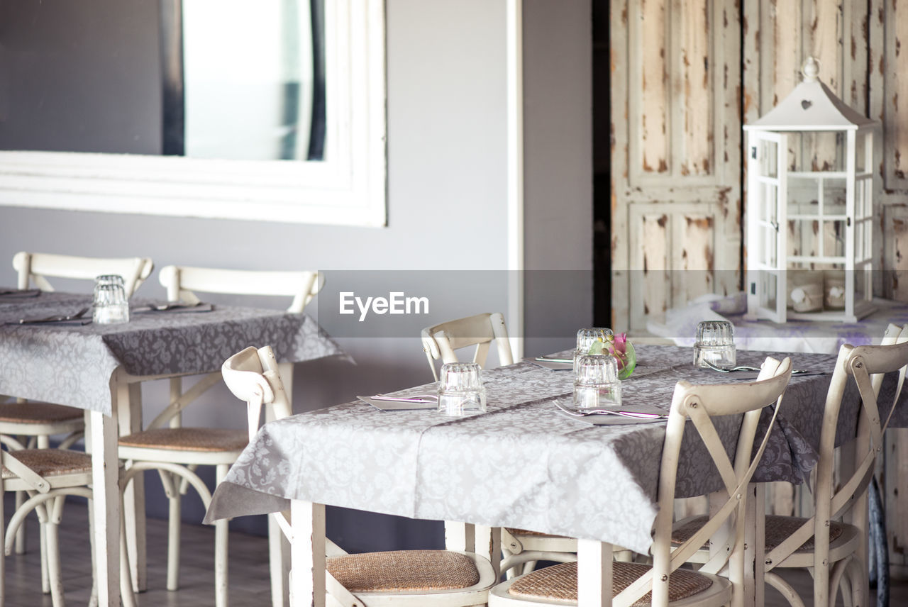 Tables and chairs arranged at shabby chic restaurant