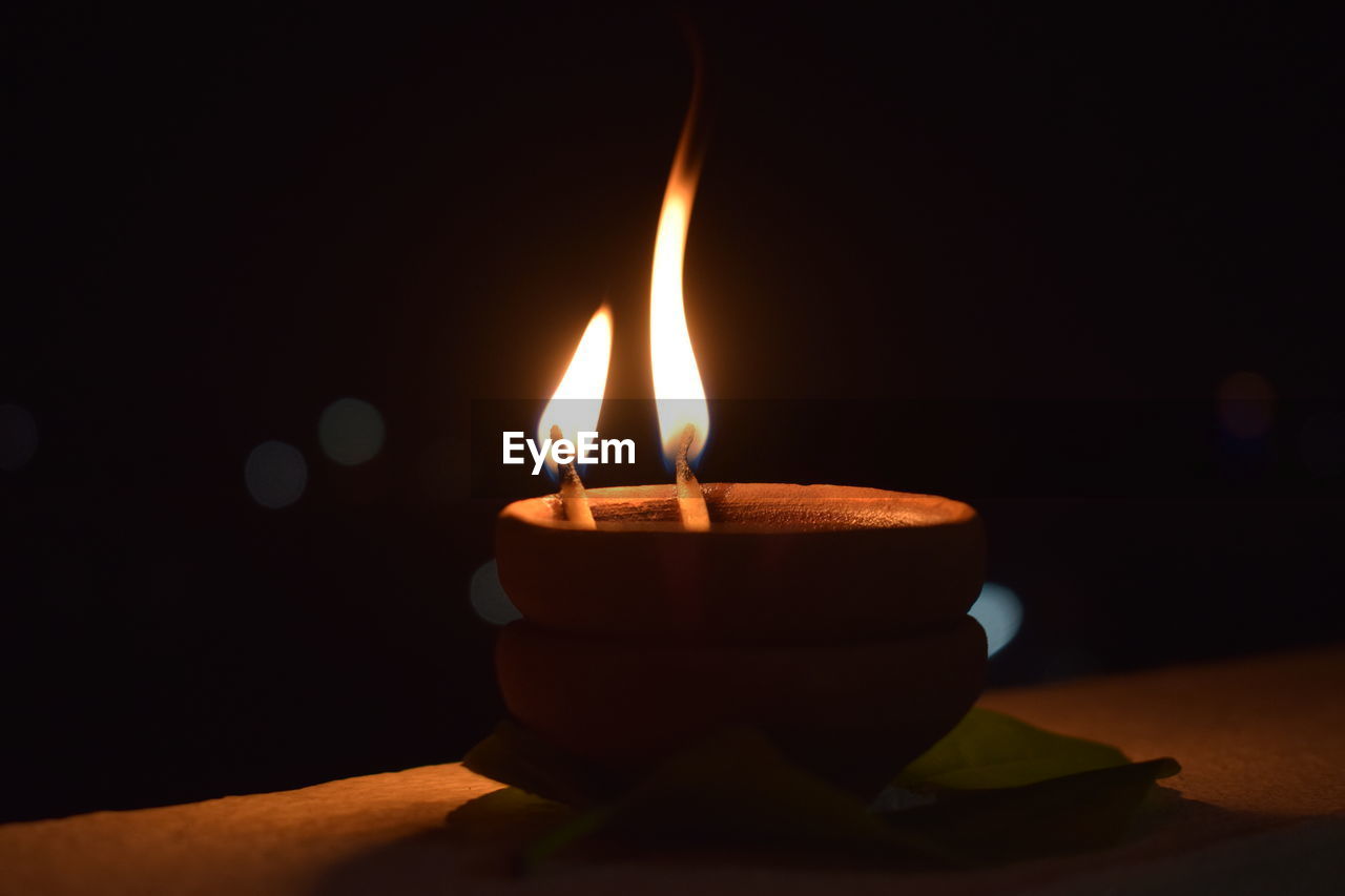 Close-up of lit diya at night