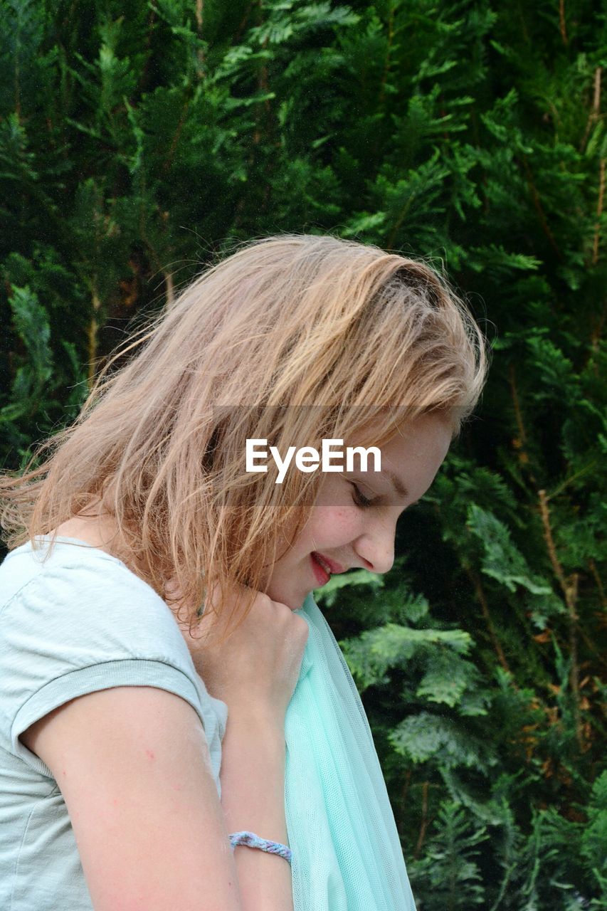 Side view of smiling girl in forest