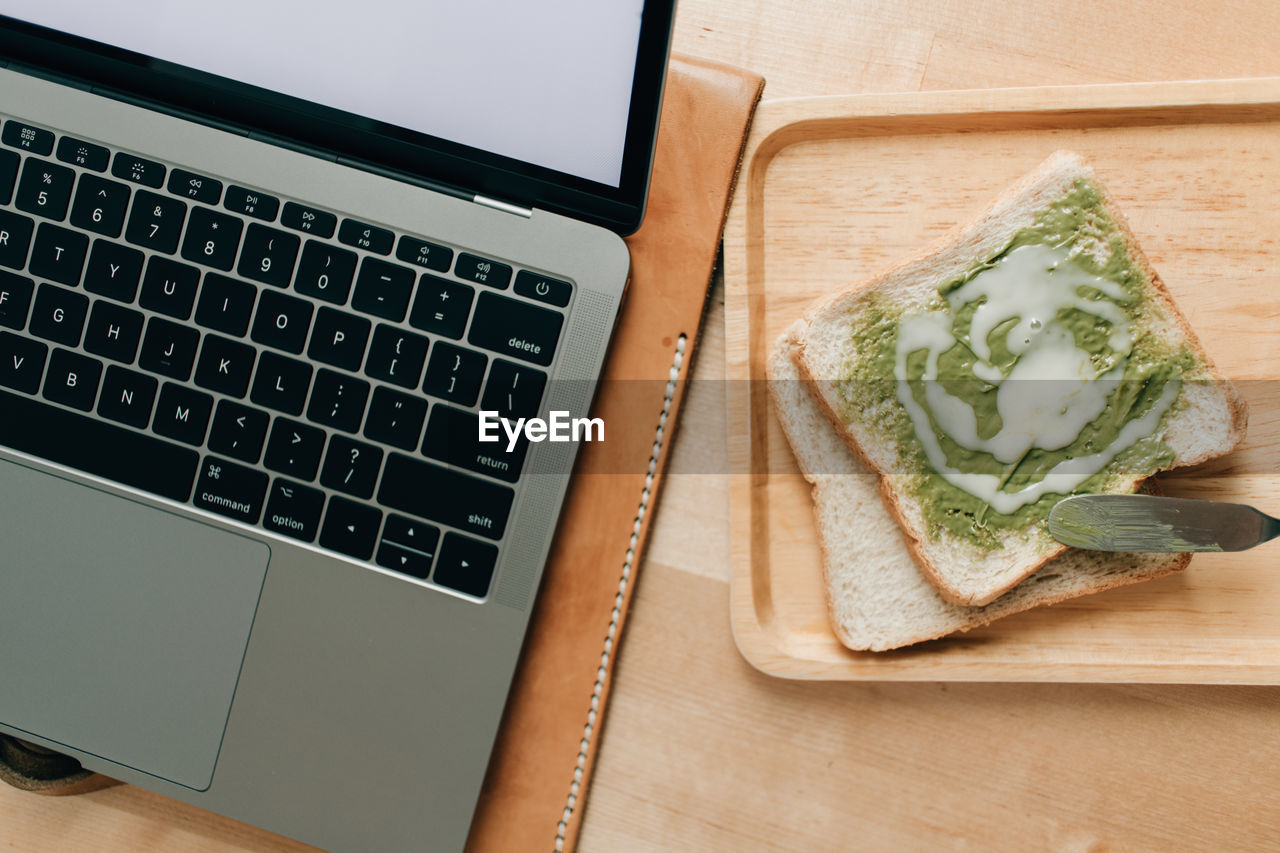 High angle view of green tea jam bread and a laptop.