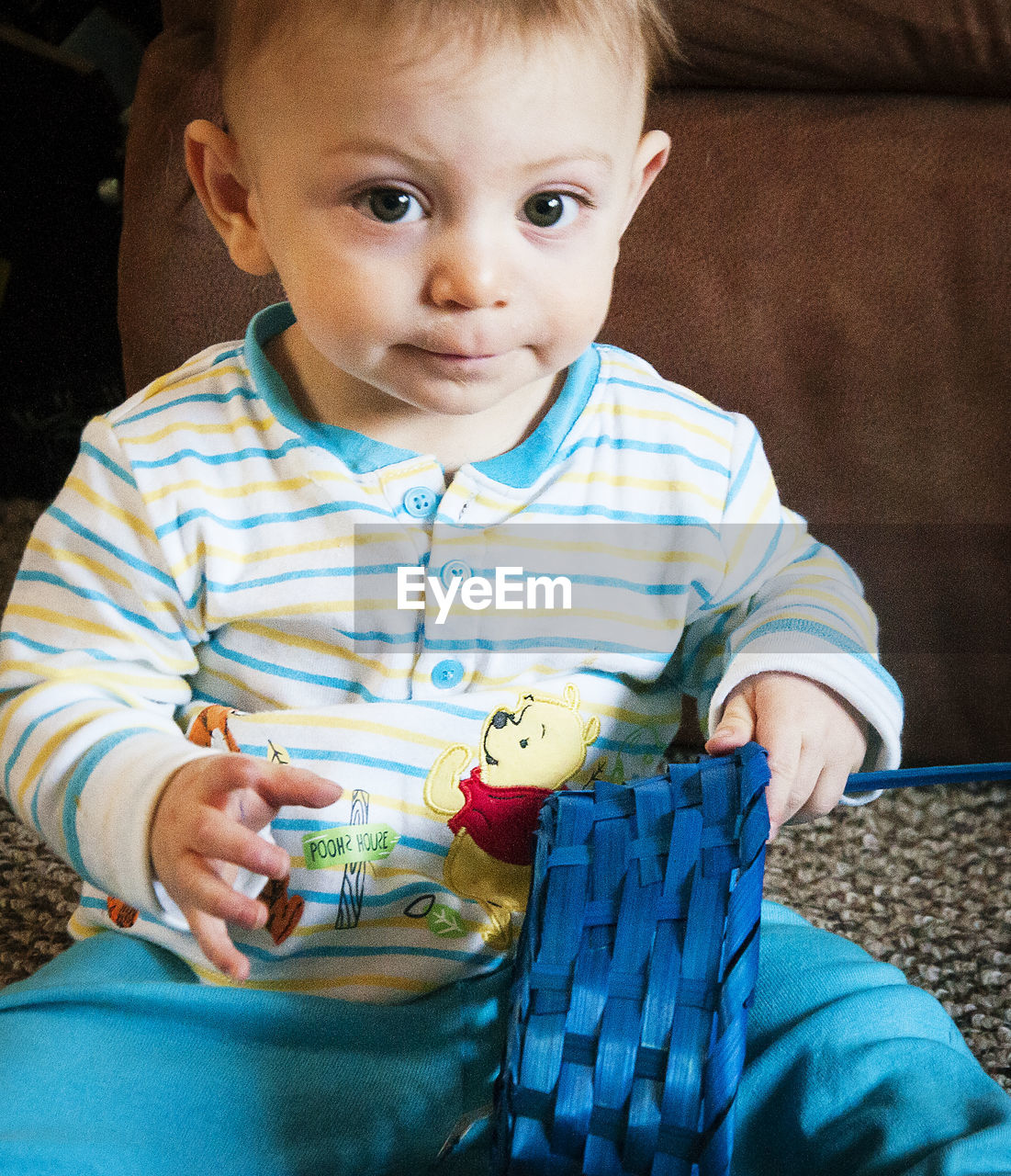 Portrait of cute boy holding blue wicker basket at home