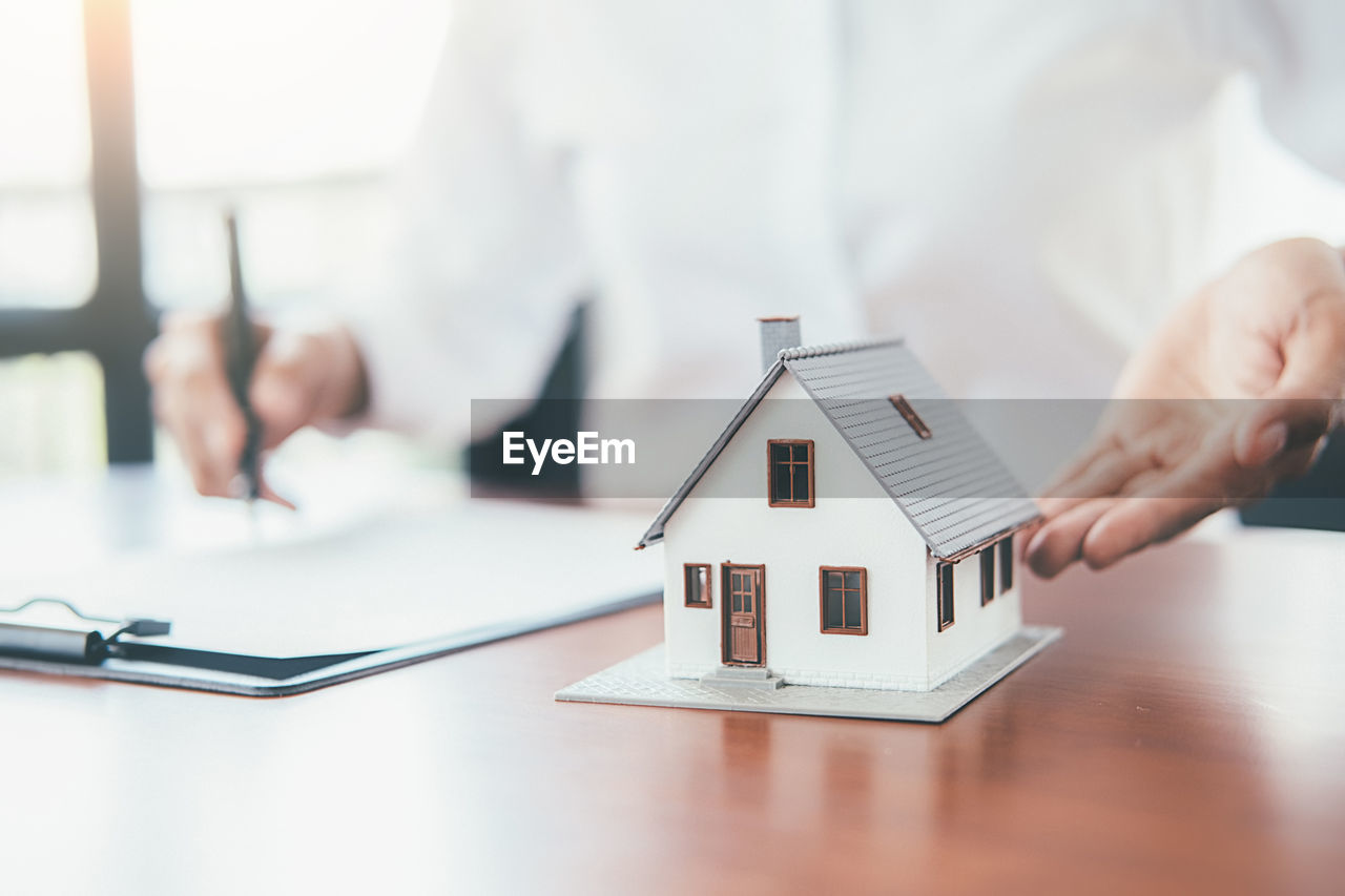 LOW ANGLE VIEW OF SMALL HOUSE ON TABLE IN BUILDING