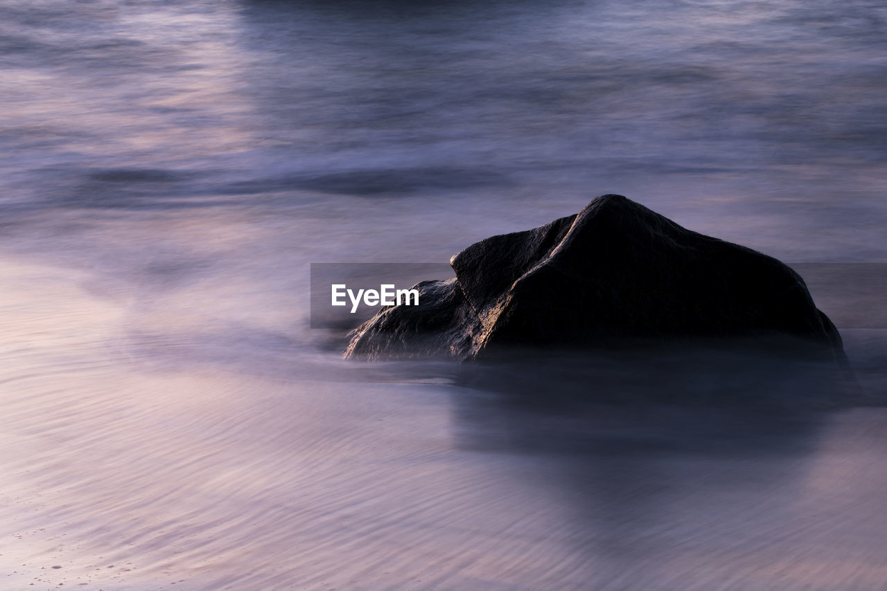 Long exposure image of rock on seashore