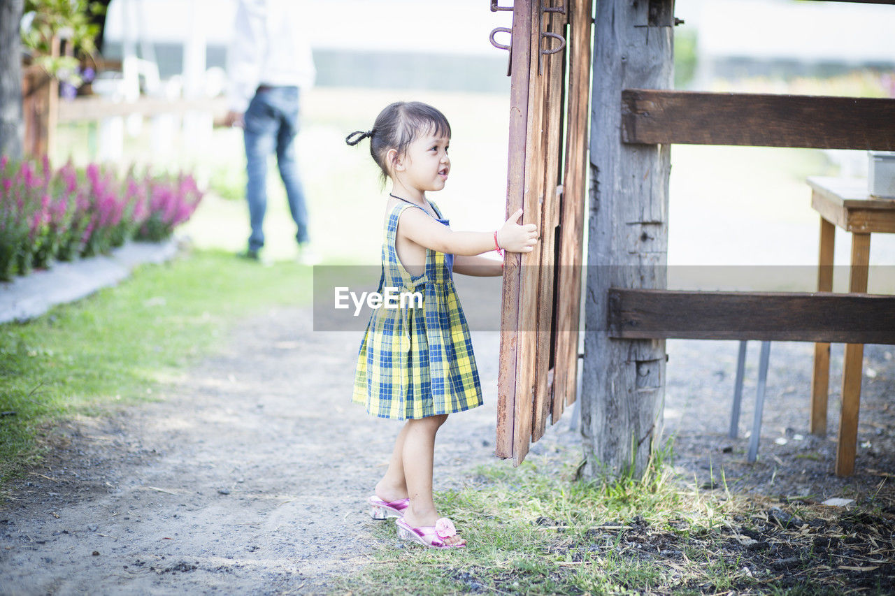 childhood, child, spring, full length, one person, female, women, dress, blue, innocence, casual clothing, toddler, standing, nature, cute, emotion, day, person, plant, lifestyles, outdoors, clothing, side view, fashion, happiness, wood, leisure activity, smiling, footwear, flowering plant, architecture, summer, flower, looking, portrait photography