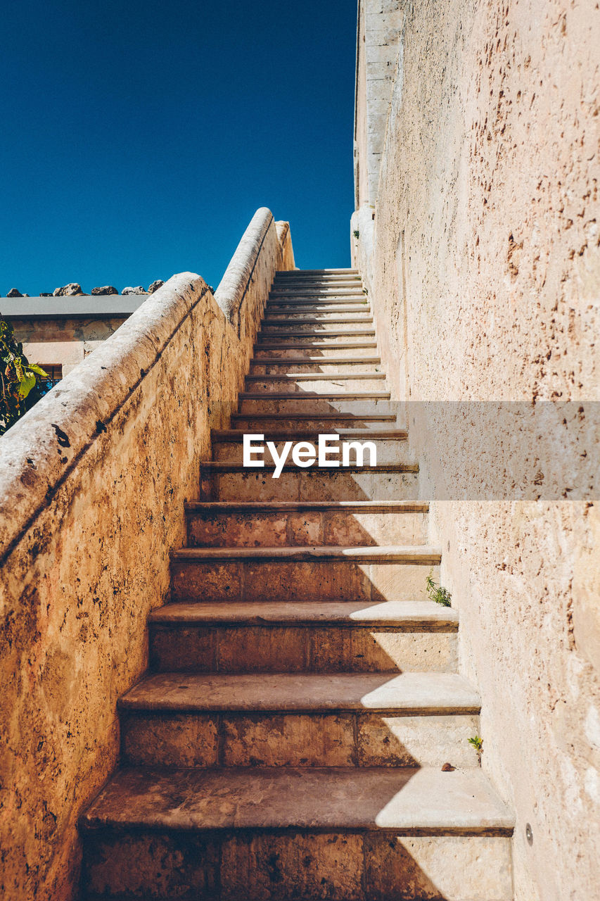 Low angle view of staircase against clear blue sky