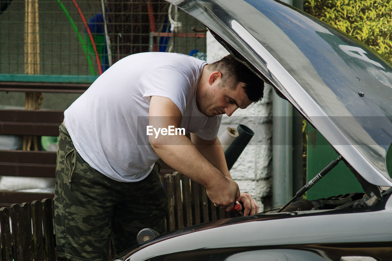 Young man repairing a car