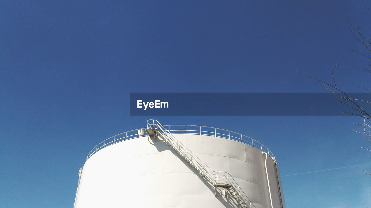 Low angle view of silo against clear blue sky