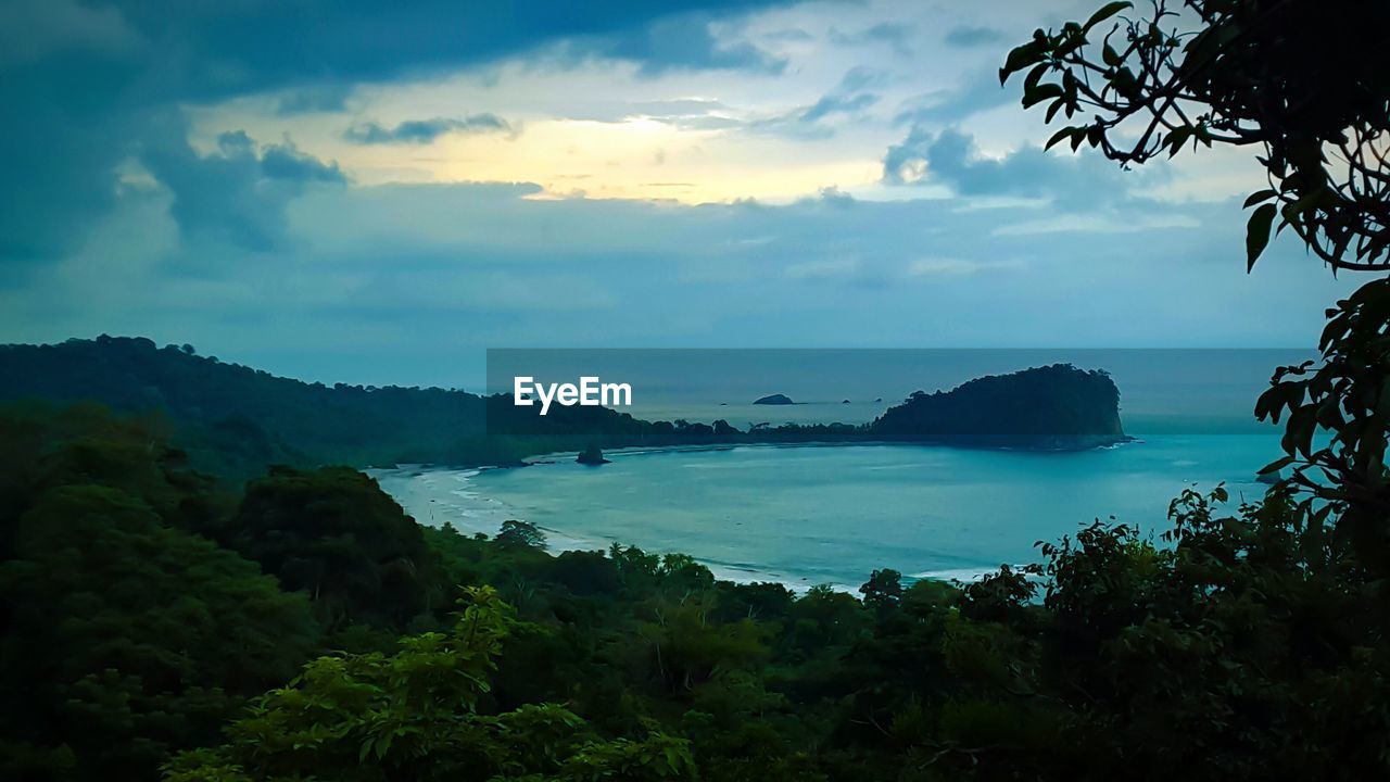 SCENIC VIEW OF SEA WITH MOUNTAIN IN BACKGROUND