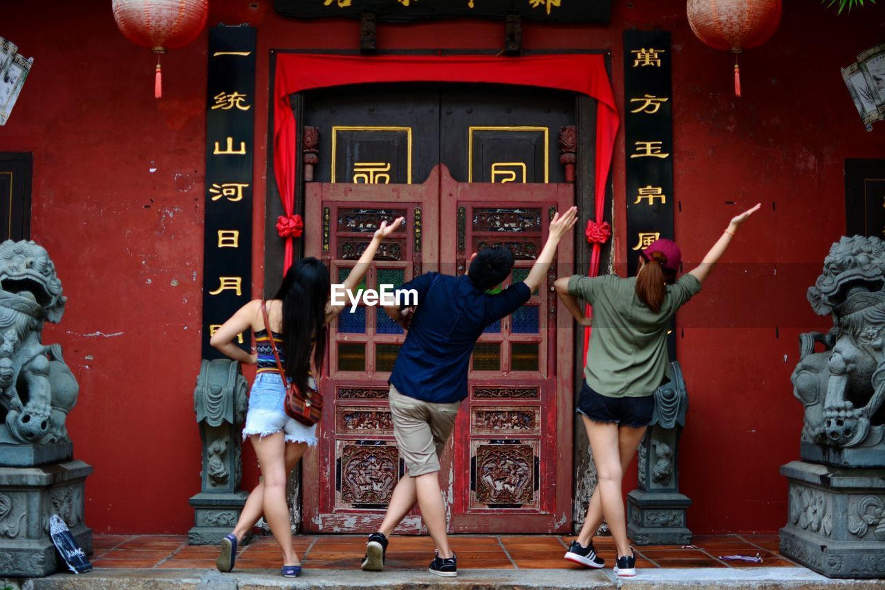 FULL LENGTH REAR VIEW OF PEOPLE WALKING IN CORRIDOR OF RED