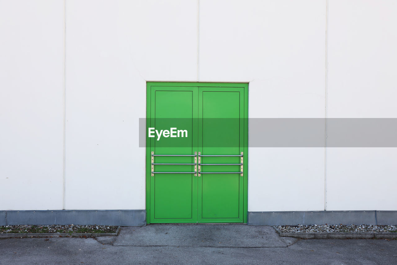 CLOSED GREEN DOOR ON WHITE WALL