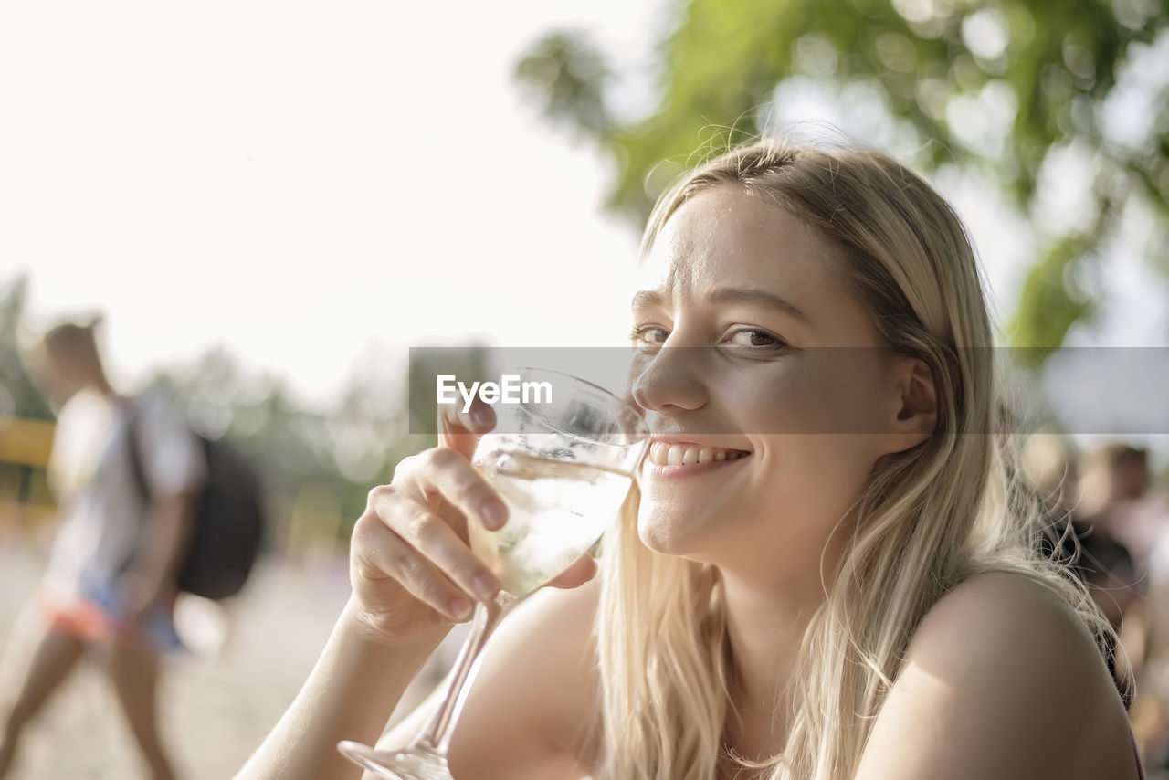 Portrait of smiling young woman having wine