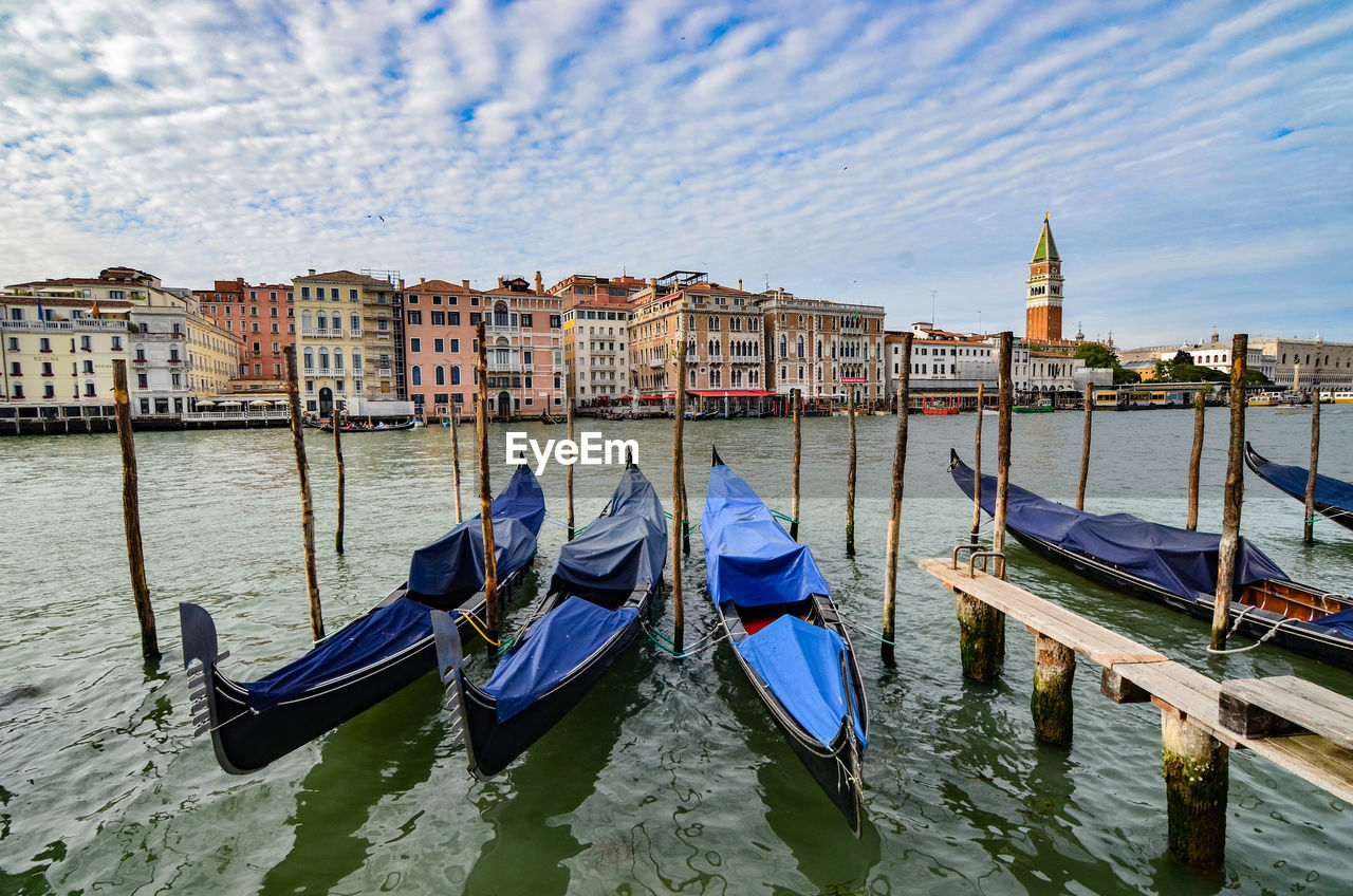 BOATS MOORED IN CANAL AGAINST BUILDINGS