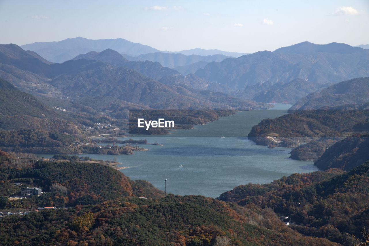 High angle view of lake and mountains against sky