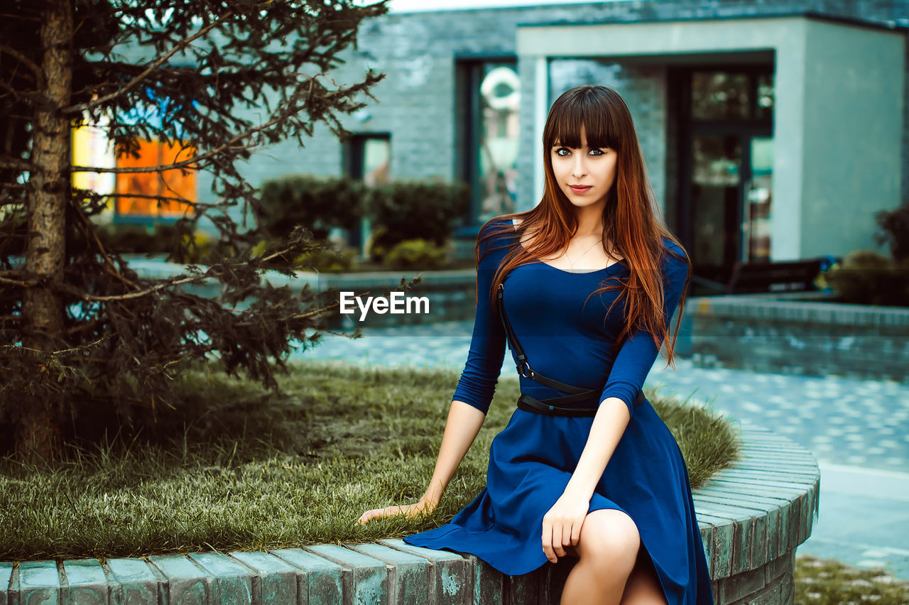 Portrait of young woman sitting outdoors