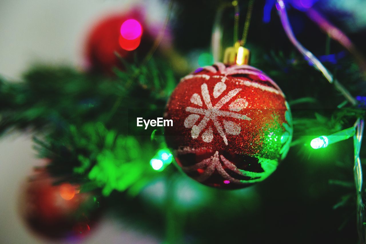 Close-up of bauble on illuminated christmas tree