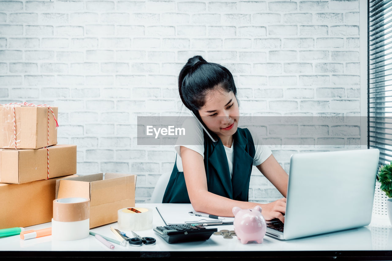 WOMAN WORKING WITH LAPTOP IN OFFICE