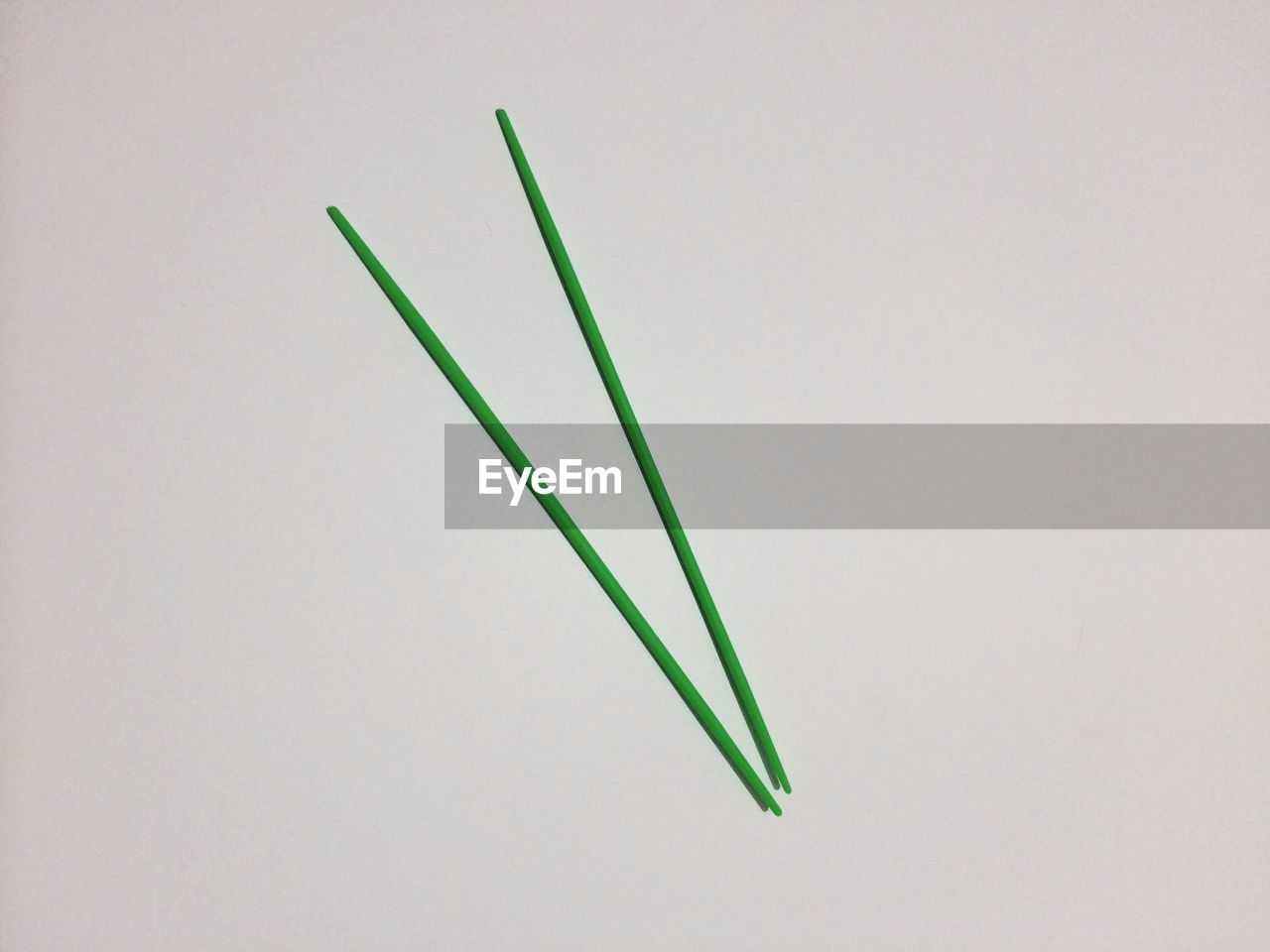 Green pick-up sticks against gray background