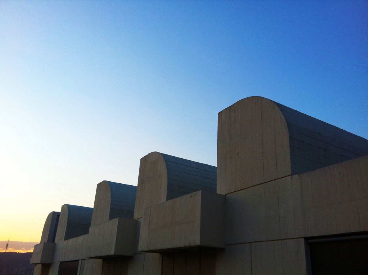 LOW ANGLE VIEW OF MODERN BUILDING AGAINST CLEAR BLUE SKY