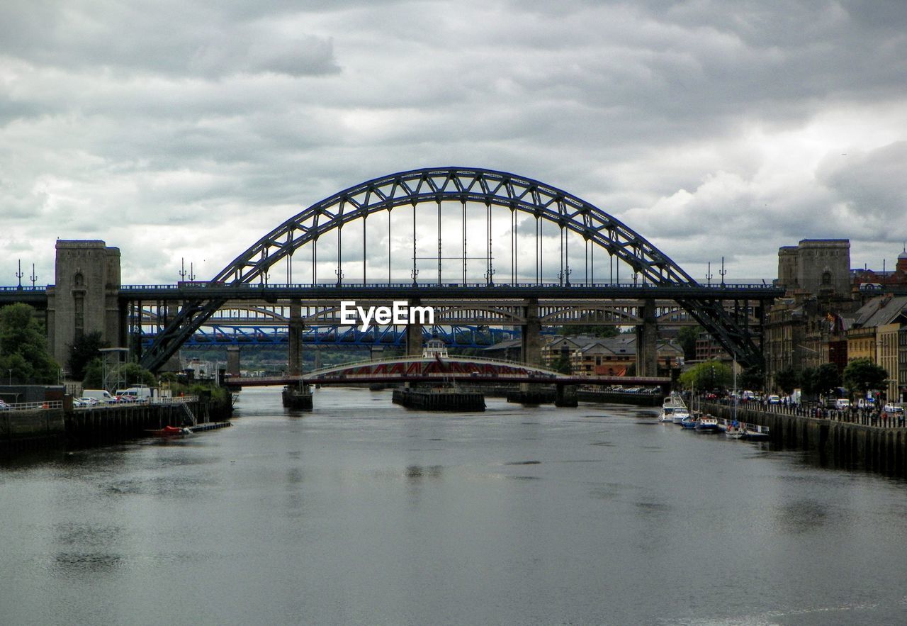 BRIDGE OVER RIVER WITH BUILDINGS IN BACKGROUND