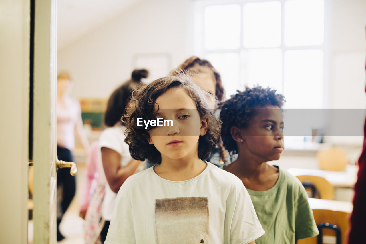 Students lining up at doorway in classroom