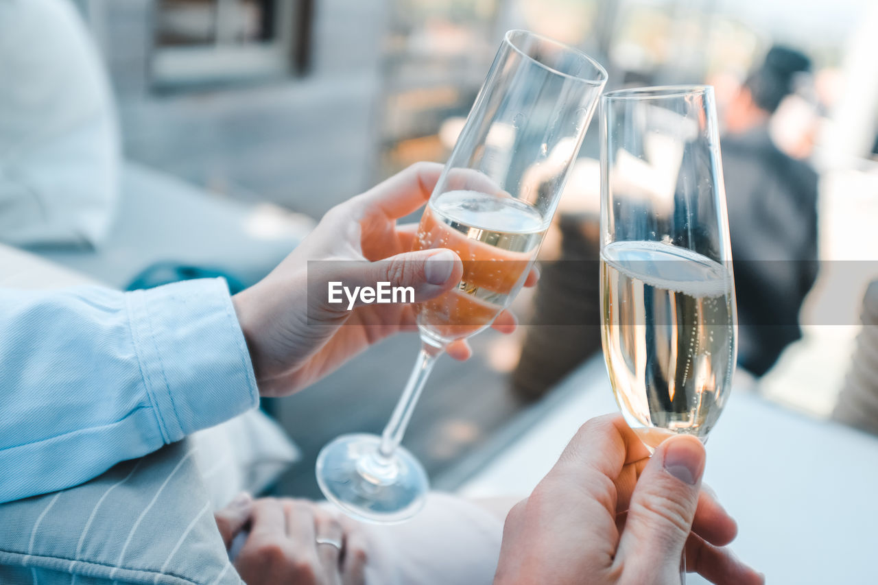 Cropped hands of people toasting champagne flutes