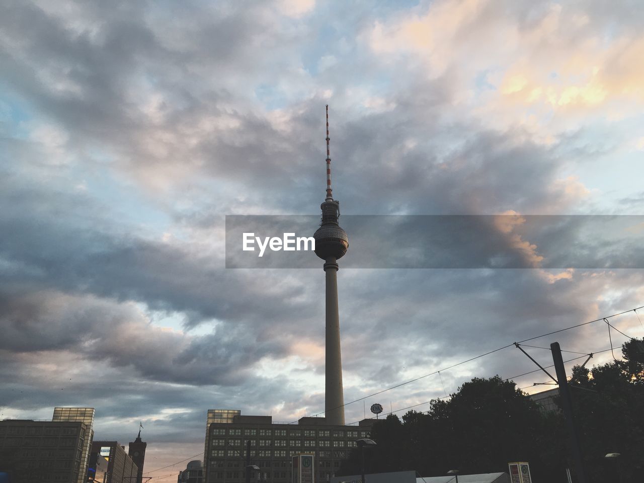 LOW ANGLE VIEW OF FERNSEHTURM TOWER AGAINST CLOUDY SKY
