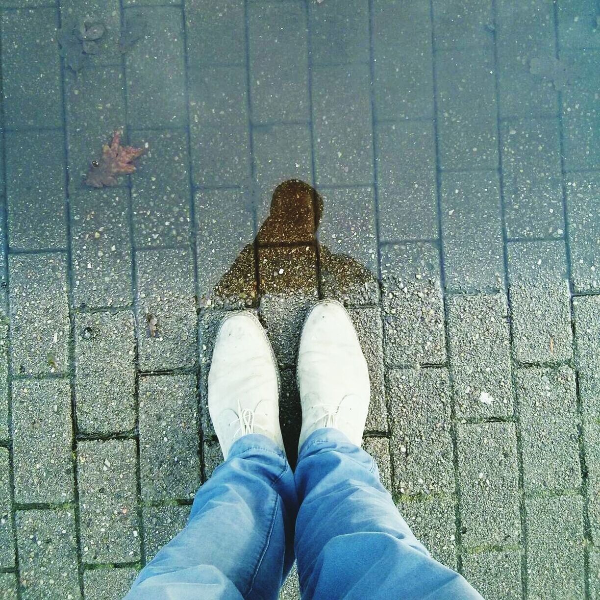 LOW SECTION OF WOMAN STANDING ON TILED FLOOR