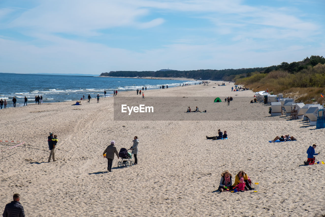 PEOPLE AT BEACH AGAINST SKY