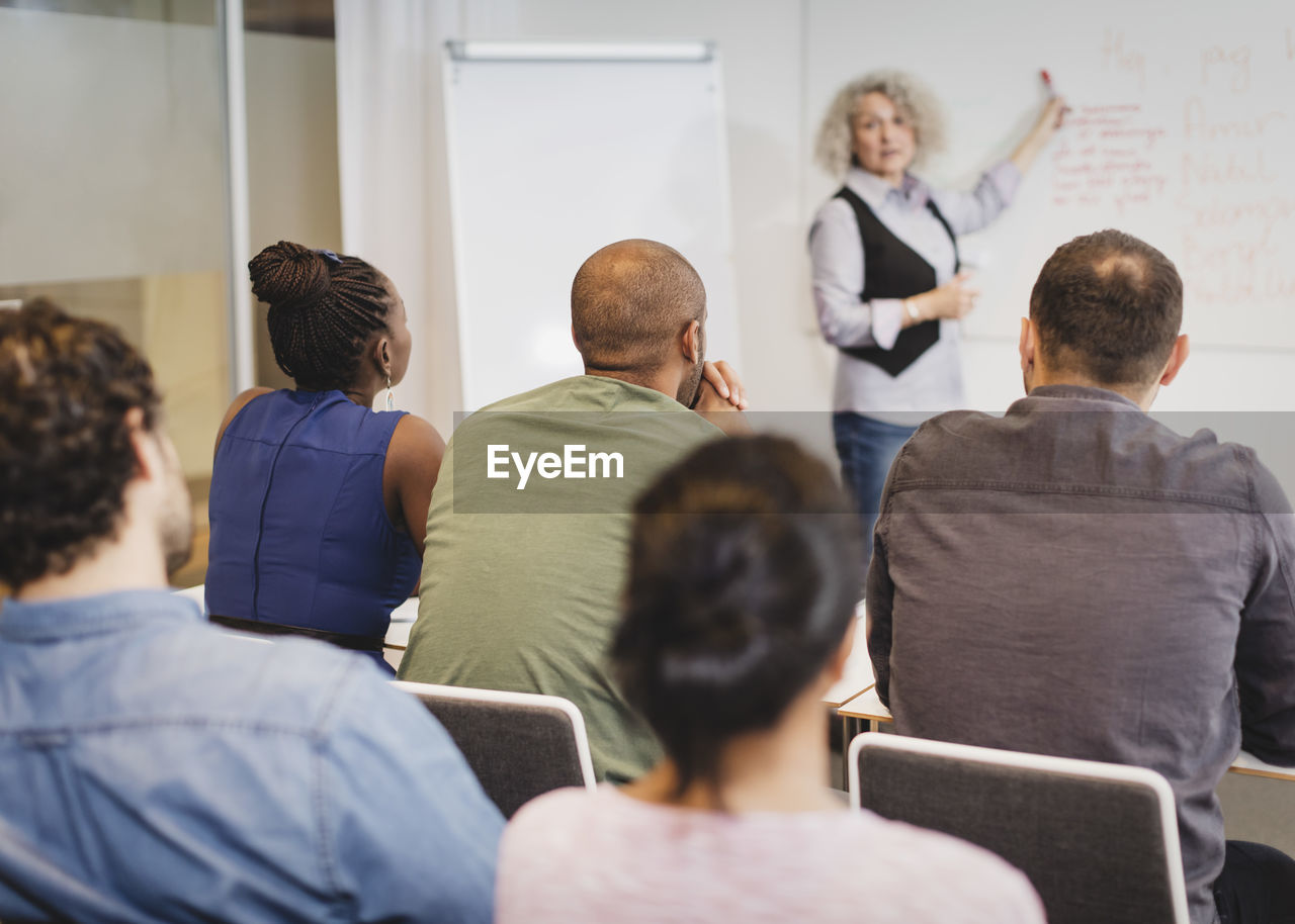 Teacher explaining to multi-ethnic students at language class