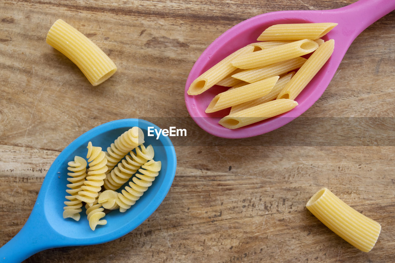 Assorted pasta and colored kitchen ladles