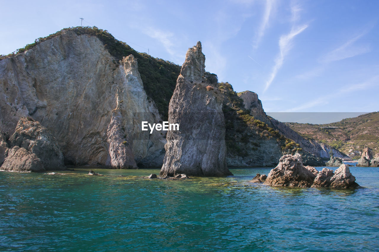 Rock formations in sea against sky