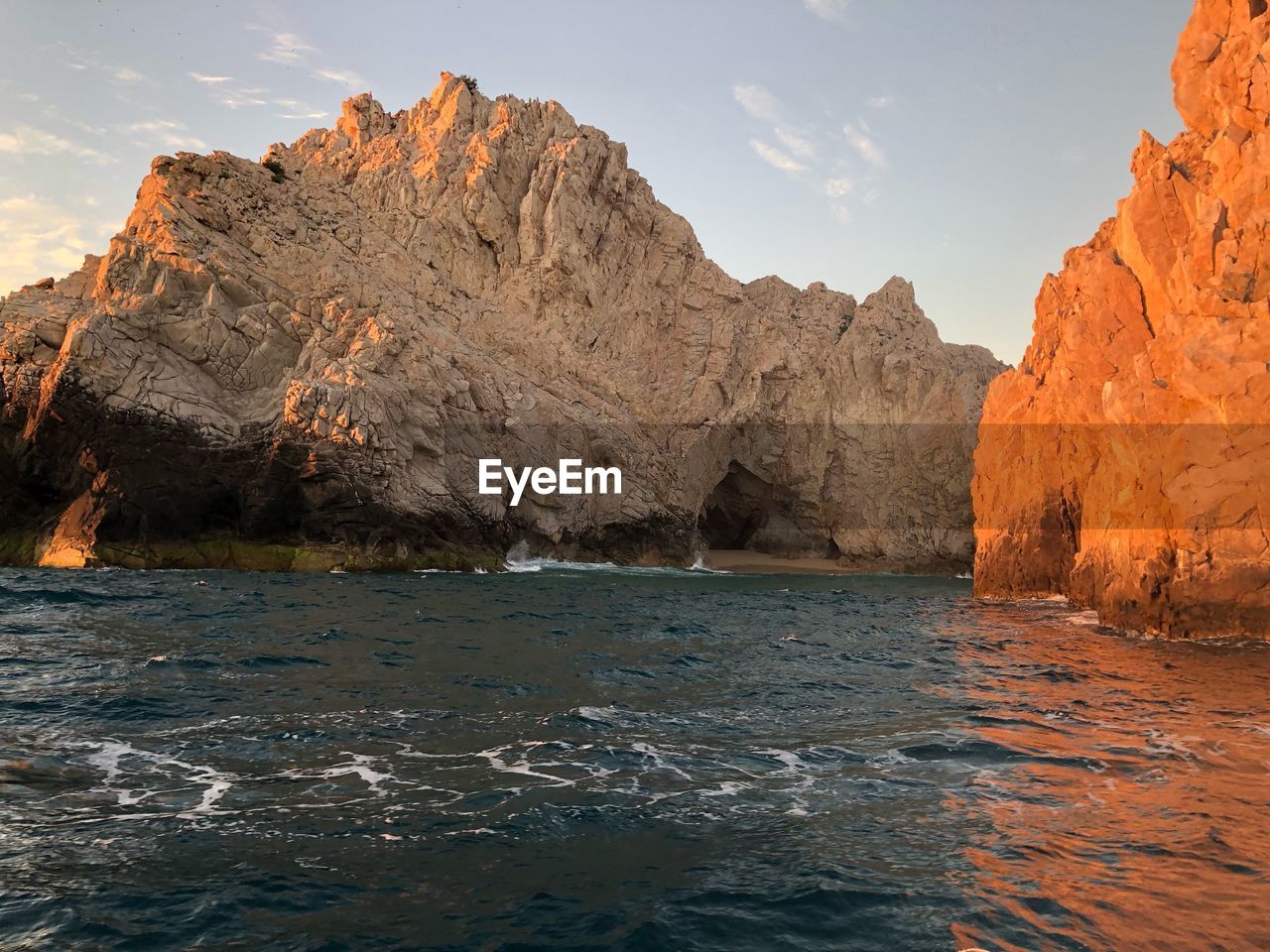 Rock formations by sea against sky