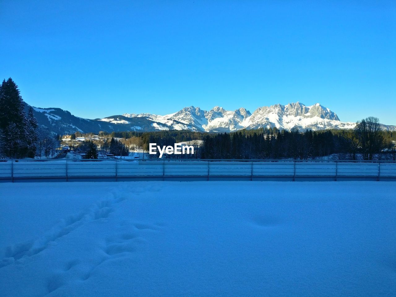 SNOW COVERED FIELD AGAINST CLEAR BLUE SKY